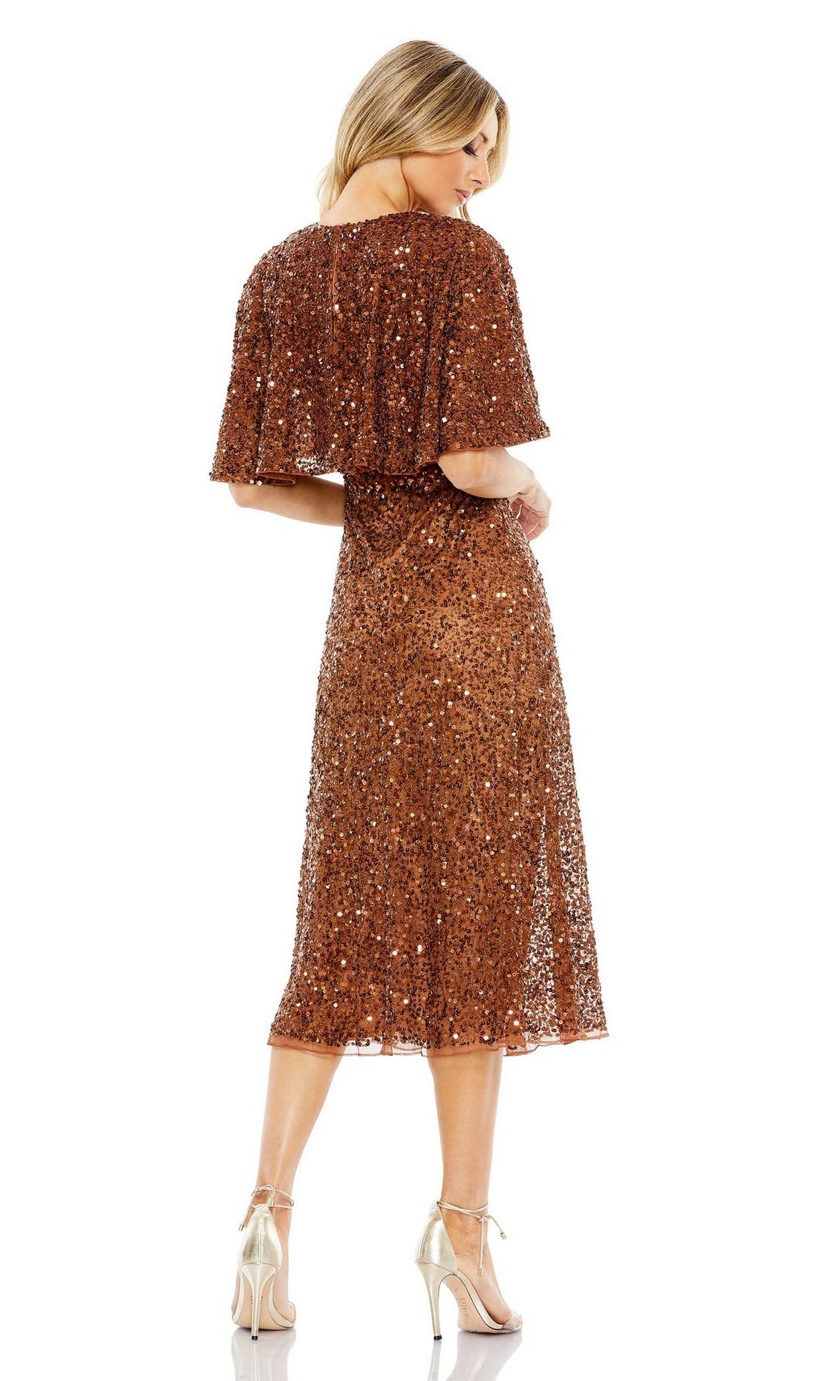 Woman in a knee-length bronze Mac Duggal 5577 Caped Midi Semi-Formal Dress and gold heels, standing with her back to the camera against a white background.